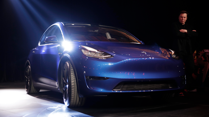 Tesla CEO Elon Musk, right, stands next to the Model Y at Tesla's design studio Thursday, March 14, 2019, in Hawthorne, Calif. The Model Y may be Tesla's most important product yet as it attempts to expand into the mainstream and generate enough cash to repay massive debts that threaten to topple the Palo Alto, Calif., company.