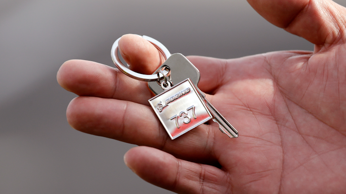 In this March 21, 2018, file photo, a Lion Air employee displays a ceremonial key to the company's newest plane following a delivery ceremony in Seattle.