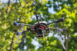 In this July 17, 2015, file photo, a Flirtey drone lowers a package of prescription medication at a clinic in Wise County, Va.