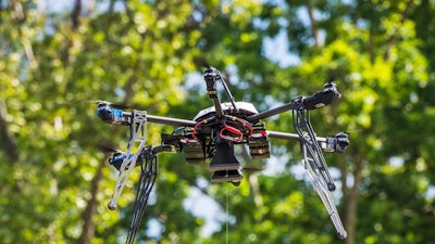 In this July 17, 2015, file photo, a Flirtey drone lowers a package of prescription medication at a clinic in Wise County, Va.