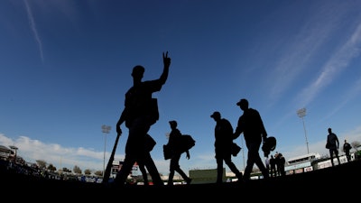 Colorado Rockies players walk off the field after a spring training baseball game against the Kansas City Royals Monday, Feb. 25, 2019, in Surprise, Ariz.