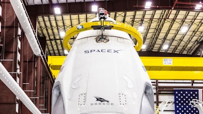 In this Dec. 18, 2018, photo, SpaceX's Crew Dragon spacecraft and Falcon 9 rocket are positioned inside the company's hangar at NASA's Kennedy Space Center.