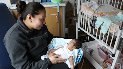 Theodora Flores holds one of her twin daughters, Genesis, in a patient room at the Ann & Robert H. Lurie Children’s Hospital of Chicago on Wednesday, Feb. 27, 2019.