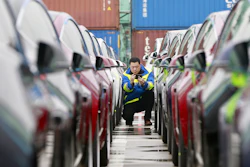 In this Feb. 22, 2019, photo, a port worker works among one of the first batches of Tesla Model 3 electric cars to be delivered to China at a port in Shanghai.