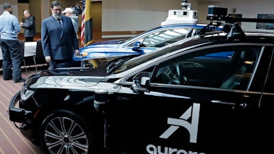 Pittsburgh Mayor William Peduto checks out autonomous vehicles designed by Aurora Innovations and Argo AI after signing an executive order Monday, March 4, 2019.