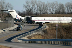 In this March 8, 2017, file photo, emergency personnel work at the scene after a plane carrying the Michigan men's basketball team slid off a runway during an aborted takeoff at Willow Run Airport, in Ypsilanti, Mich.