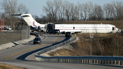 In this March 8, 2017, file photo, emergency personnel work at the scene after a plane carrying the Michigan men's basketball team slid off a runway during an aborted takeoff at Willow Run Airport, in Ypsilanti, Mich.