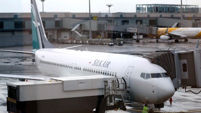 In this Oct. 4, 2017, file photo, SilkAir's new Boeing 737 Max 8 aircraft is seen through a viewing gallery window parked on the tarmac of Singapore's Changi International Airport.