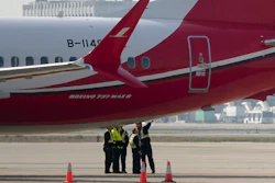 Ground crew chat near a Boeing 737 MAX 8 plane parked on the tarmac at Hongqiao airport in Shanghai, Tuesday, March 12, 2019.