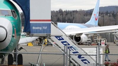 In this photo taken Monday, March 11, 2019, a Boeing 737 MAX 8 airplane sits parked in the background at right at Boeing Co.'s Renton Assembly Plant in Renton, Wash.