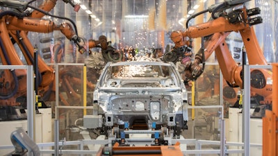 In this Saturday, March 9, 2019, file photo, robots work on a VW Passat car at a plant in Emden, Germany.