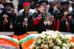 Church leaders pray next to empty caskets draped with the national flag at a mass funeral at the Holy Trinity Cathedral in Addis Ababa, Ethiopia, Sunday, March 17, 2019.