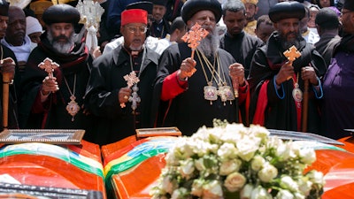 Church leaders pray next to empty caskets draped with the national flag at a mass funeral at the Holy Trinity Cathedral in Addis Ababa, Ethiopia, Sunday, March 17, 2019.