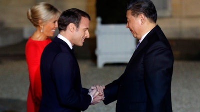 French President Emmanuel Macron and his wife Brigitte Macron welcome Chinese President President Xi Jinping prior to a state dinner at the Elysee Palace in Paris, Monday, March 25, 2019.