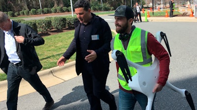Matternet CEO Andreas Raptopoulos walks next to an operator carrying a drone used for delivery of medical specimens after a flight at WakeMed Hospital in Raleigh, N.C., on March 26, 2019.