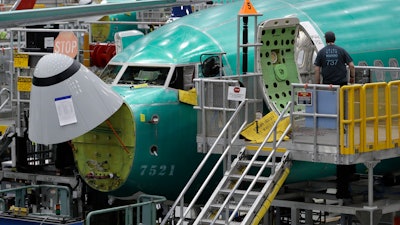 A worker enters a Boeing 737 MAX 8 airplane during a brief media tour of Boeing's 737 assembly facility, Wednesday, March 27, 2019, in Renton, Wash.