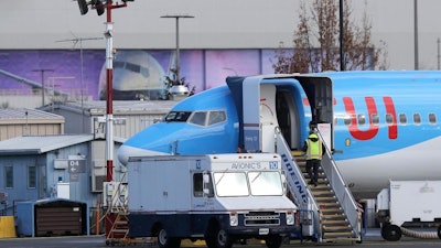 A worker walks up steps to the right of an avionics truck parked next to a Boeing 737 MAX 8 airplane being built for TUI Group at Boeing Co.'s Renton Assembly Plant Wednesday, March 13, 2019, in Renton, Wash. President Donald Trump says the U.S. is issuing an emergency order grounding all Boeing 737 Max 8 and Max 9 aircraft in the wake of a crash of an Ethiopian Airliner.