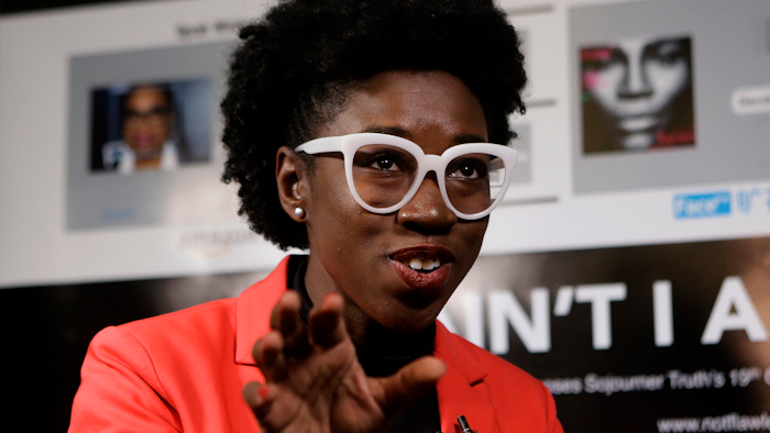 In this Feb. 13, 2019, photo, Massachusetts Institute of Technology facial recognition researcher Joy Buolamwini takes questions from reporters at the school in Cambridge, Mass.