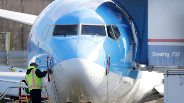 In this March 13, 2019, file photo, a worker stands on a platform near a Boeing 737 MAX 8 airplane at Boeing Co.'s Renton Assembly Plant in Renton, Wash.