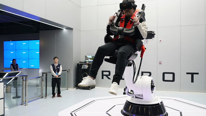 In this April 2, 2019, photo, a visitor rides a virtual roller coaster ride operated by a robotic arm in a VR theme park in Nanchang, China.