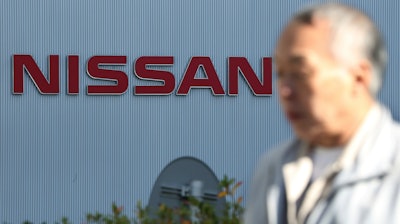 In this Jan. 9, 2019, photo, a man walks past the logo at global headquarters of Nissan Motor Co. in Yokohama.