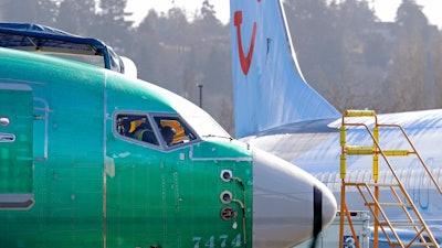 In this March 13, 2019, file photo, people work in the flight deck of a Boeing 737 MAX 8 airplane at Boeing Co.'s Renton Assembly Plant in Renton, Wash.