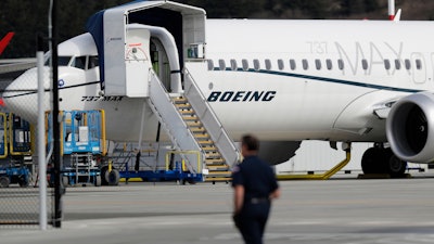 In this March 14, 2019, file photo, a worker walks next to a Boeing 737 MAX 8 airplane parked at Boeing Field in Seattle.
