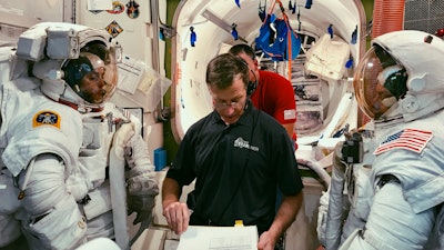 In this February 2019 photo, Boeing astronaut Chris Ferguson helps NASA astronauts Nicole Mann, left, and Mike Fincke, right, train for a spacewalk inside the International Space Station Airlock Mockup at NASA's Johnson Space Center in Houston.