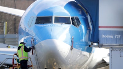 In this March 13, 2019, file photo, a worker stands on a platform near a Boeing 737 MAX 8 airplane at Boeing Co.'s Renton Assembly Plant in Renton, Wash.