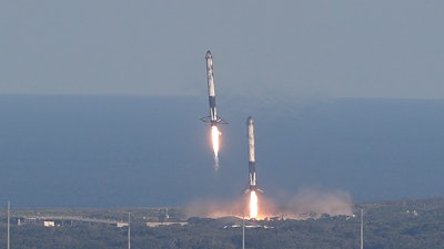 Eight minutes after liftoff, SpaceX lands two of the first-stage boosters side by side at the Kennedy Space Center in Cape Canaveral, Fla., Thursday, April 11, 2019.