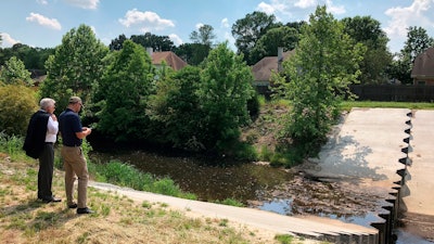 In this May 15, 2018, file photo, two men inspect a U.S. Army Corps of Engineers project to prevent erosion in an important storm sewage channel in Germantown, Tenn.