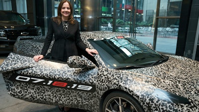 GM chairman and CEO Mary Barra standing by a camouflaged next generation Chevrolet Corvette Thursday, April 11, 2019, in New York.
