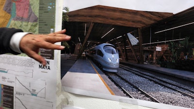Rogelio Jiménez Pons, director of Fonatur, points to photos of a planned train through the Yucatan Peninsula during an interview in Mexico City, Monday, March 18, 2019.