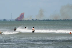 A cloud of orange smoke rises over Cape Canaveral Air Force Station as seen from Cocoa Beach, Fla., Saturday, April 20, 2019.