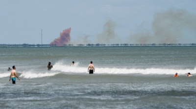 A cloud of orange smoke rises over Cape Canaveral Air Force Station as seen from Cocoa Beach, Fla., Saturday, April 20, 2019.