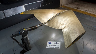 Wing assembly is seen under construction, assembled from hundreds of identical subunits. The wing was tested in a NASA wind tunnel.