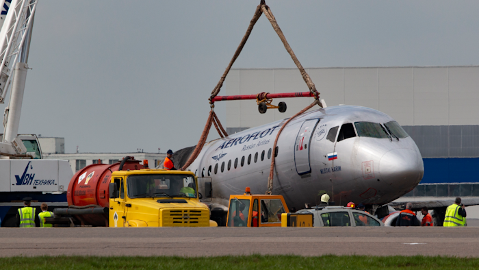 A crane lifts the damaged Sukhoi SSJ100 aircraft of Aeroflot Airlines in Sheremetyevo airport outside Moscow, Monday, May 6, 2019.