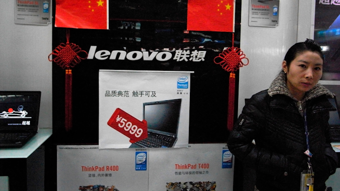 In this Jan 8, 2009, file photo, a vendor waits for customers at a computer shop selling Lenovo laptops in Beijing.