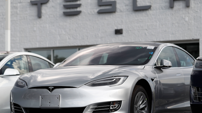 This July 8, 2018, photo shows Tesla 2018 Model 3 sedans on display outside a showroom in Littleton, Colo.