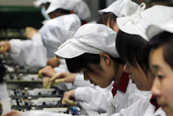 In this Wednesday, May 26, 2010, file photo, staff members work on the production line at the Foxconn complex in Shenzhen, China.