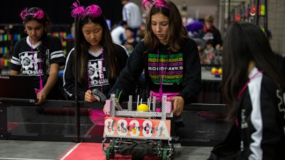 In this Thursday, April 25, 2019, photo, Amisha Chandra (far left), Elina Kim, Olivia Ramirez and Kristina Tu of the Orchard Hills, Calif., RoboHawks team practice at the VEX World Robotics Championships in Louisville, Ky.