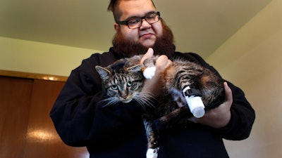 Adam Schofield holds his tabby cat Sgt. Stubbs in his Oak Creek, Wis., apartment, Friday, May 3, 2019.