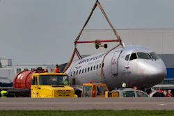 A crane lifts the damaged Sukhoi SSJ100 aircraft of Aeroflot Airlines in Sheremetyevo airport outside Moscow, Monday, May 6, 2019.