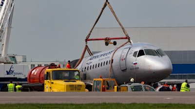 A crane lifts the damaged Sukhoi SSJ100 aircraft of Aeroflot Airlines in Sheremetyevo airport outside Moscow, Monday, May 6, 2019.