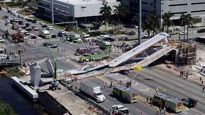 In this March 15, 2018, file photo, emergency personnel respond after a brand-new pedestrian bridge collapsed onto a highway at Florida International University in Miami.
