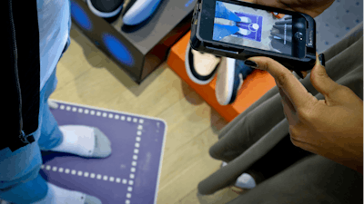 Nike officials demonstrate the company's foot-scanning tool on its app Wednesday April 24, 2019, in New York.