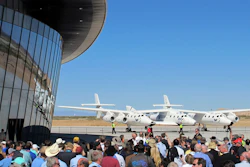 In this Oct. 17, 2011, file photo, a crowd gathers outside Spaceport America near Upham, N.M., for a dedication ceremony as Virgin Galactic's WhiteKnightTwo sits on the tarmac.