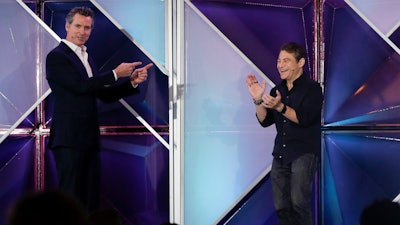 California Gov. Gavin Newsom, left, jokes with X Prize founder and chairman Peter Diamandis during the Near Future conference, Friday, May 10, 2019, in San Diego.