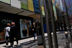 Shoppers walk by foreign fashion boutiques at the capital city's popular shopping mall in Beijing, Monday, May 13, 2019.