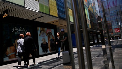 Shoppers walk by foreign fashion boutiques at the capital city's popular shopping mall in Beijing, Monday, May 13, 2019.